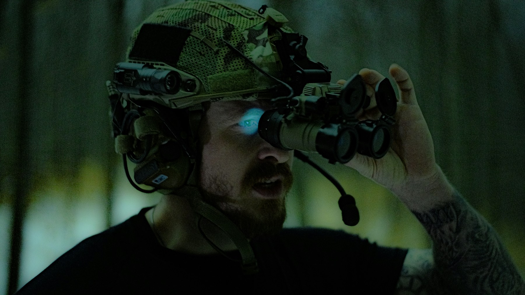 A tactical operator adjusting night-vision goggles